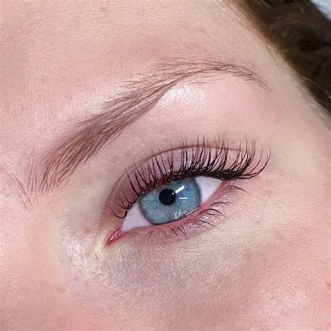 Classic lash extensions close-up on a blue eye, one extension per natural lash for a defined, mascara-like lash line