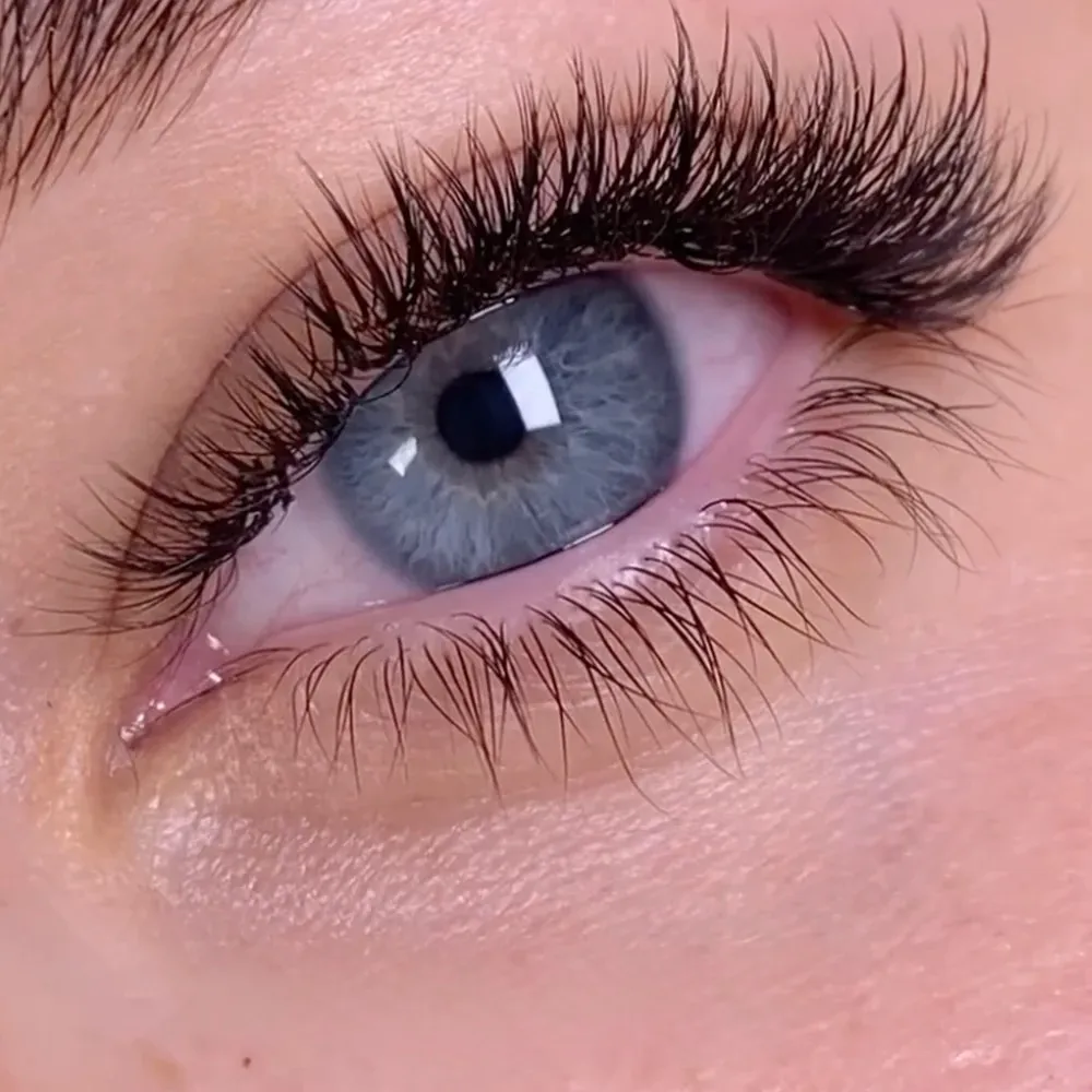 Hybrid lash extensions close-up, classic extensions mixed with volume fans for a textured, wispy lash line